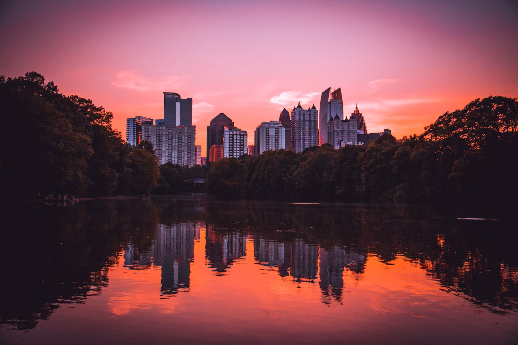 The Midtown Atlanta skyline at sunset, reflected in a lake